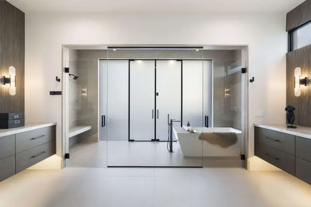 A primary bathroom with a floor-to-ceiling GCS glass enclosure