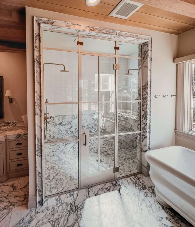 A frameless marble shower by GCS Glass