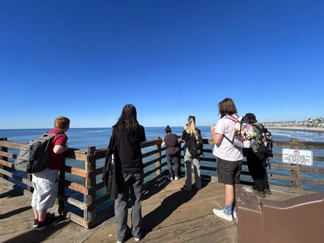 A Perfect Fit group on a pier, looking out over the ocean